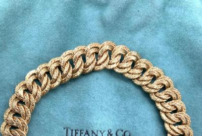 在设计师珠宝中是这款Tiffany＆Co.18K金链条遏制链接手链，法国（500-2,000美元），措施7英寸长。