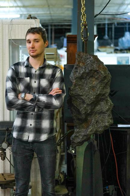 63号画廊的老板伊利亚·布朗站在一块巨大的博物馆级陨石旁边，这块陨石将于东部时间4月6日星期二上午11点在网上出售。这个架子有74英寸高。