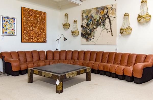 20世纪60年代，De-Sede设计的DS-600沙发围绕着保罗·埃文斯设计的定向咖啡桌。上面的墙上装饰着好莱坞摄政风格的壁灯和当代艺术作品。